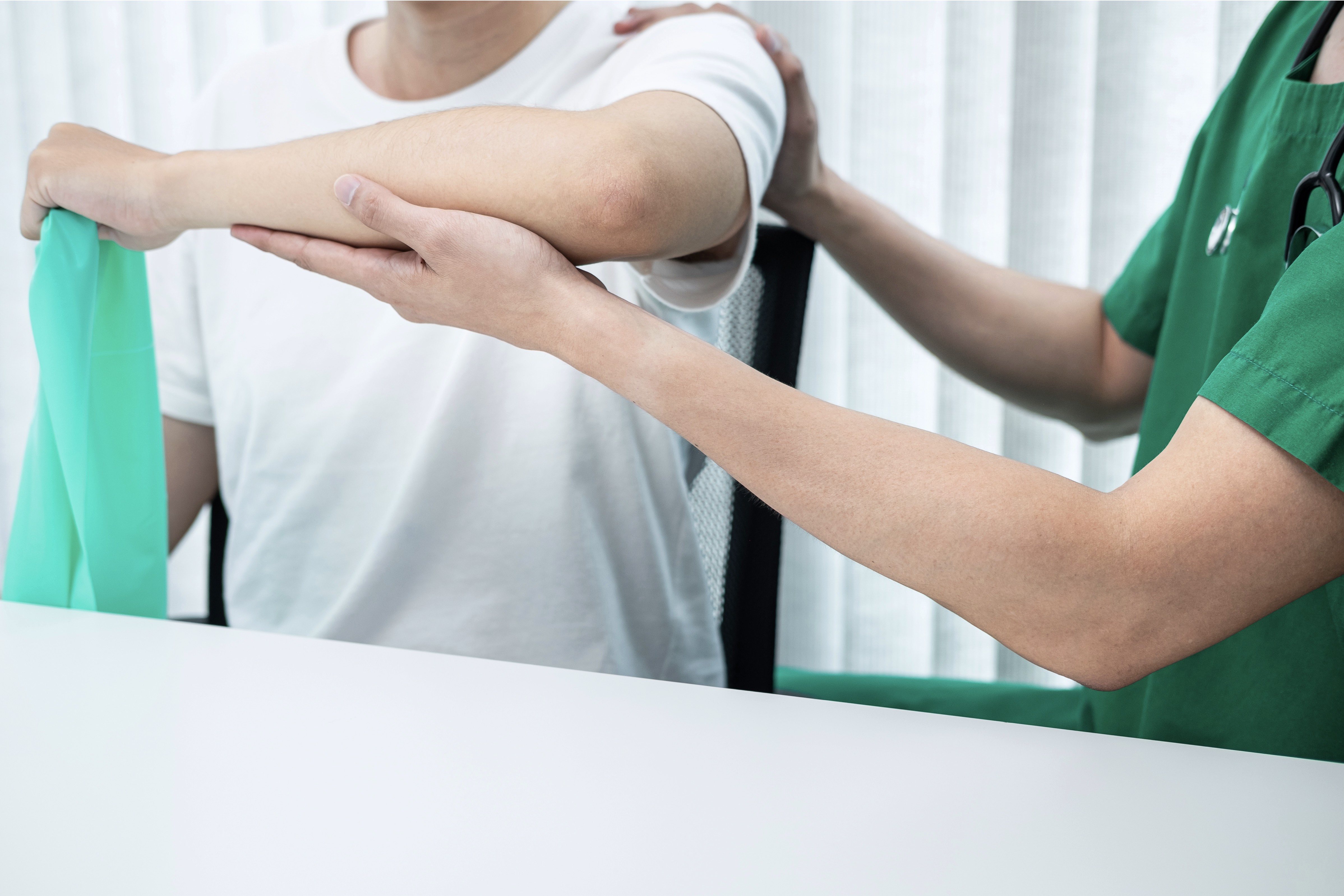 physiotherapist working examining treating injured arm athlete patient stretching exercise rehabilitation clinic